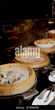 Dampfender Dim Sum in Bambuskörben im Restaurant mit asiatischer Darstellung Stockfoto