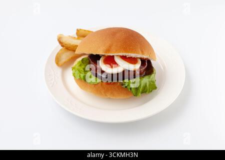 teriyaki Hamburger mit gekochtem Ei auf Platte isoliert auf weißem Hintergrund Stockfoto