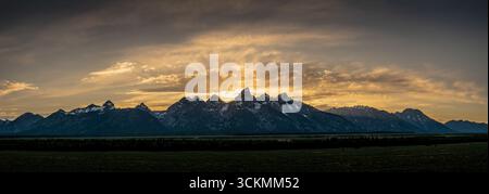 Sonnenstrahlen erstrahlen aus dem Sonnenuntergang hinter dem Panorama der Grand Teton Mountain Range im Sommer Stockfoto