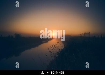 Sonnenaufgang über dem Fluss am nebeligen Morgen. Hochwertige Fotos Stockfoto