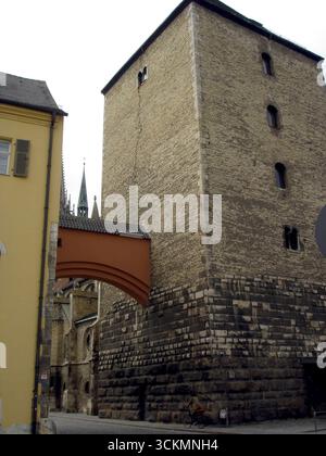 Besucher bewundern den beeindruckenden römischen Turm in Regensburg, ein atemberaubendes Beispiel für antike Architektur, die sich mit charmantem urbanen Leben verbindet. Stockfoto
