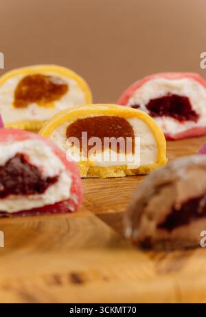 Verschiedene bunte Mochi-Eishälften auf Holzbrett, Nahaufnahme, Studiobeleuchtung Stockfoto