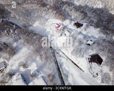 Drohnenansicht des Dorfes Madarao, bedeckt mit tiefem Schnee in Nagano, Japan Stockfoto