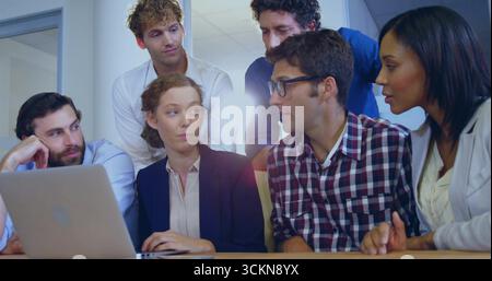 Zusammenarbeit mit Business Gelegenheitsexperten, die im Büro am Tisch mit einem Laptop herumtippen und diskutieren Stockfoto