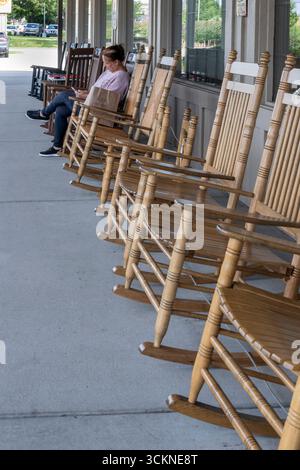 Olathe, Kansas. Frau mit Telefon im Schaukelstuhl auf der Ladenfront des Cracker Barrel Restaurants mit seiner gutbürgerlichen Landküche und g Stockfoto