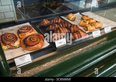 Ein Arrangement verschiedener Backwaren, darunter Zimtrollen, Rugelach und herzhaftes Gebäck, ausgestellt in einem Glaskoffer, The Rocks, Sydney, New Sou Stockfoto