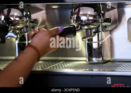Cremona, Italien – 19. Juli 2025 Nahaufnahme eines erfahrenen Barista, der mit einer kommerziellen Kaffeemaschine einen frischen Espresso zubereitete, um einen perfekten Kaffee zu kreieren Stockfoto