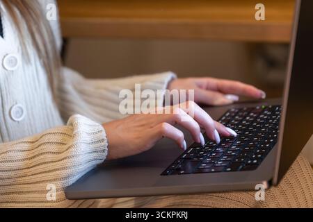 Junge Frau, die mit Daten über Laptop-Nahaufnahme arbeitet. Praktische Bedienung der Tastatur. Stockfoto