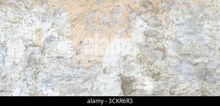 Nahaufnahme einer verwitterten Wand, die Schichten von rissiger Farbe und Putz freilegt und einen strukturierten Vintage-Hintergrund schafft Stockfoto