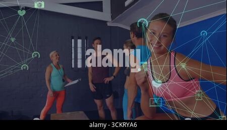 Anliegende Frau im Sport-BH, die die Daumen hoch auf der Box im Fitnessstudio hält, mit Klemmbrett, Kopierraum Stockfoto