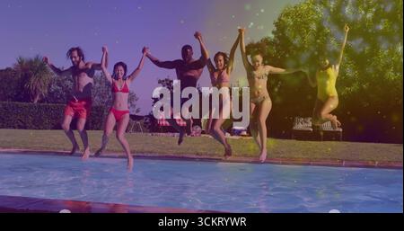Springende Gruppe von sechs Freunden, die Hände am Hinterhof-Pool halten, mit Badeanzügen und aufblasbarem Ball Stockfoto