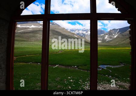 Blick auf die Berge vom Fenster einer Berghütte im Frühling Stockfoto