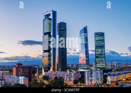 Stadtbild von Madrids Finanzviertel in der Abenddämmerung mit modernen Wolkenkratzern, die vor dem verblassenden Abendhimmel beleuchtet werden. Dieses Gebiet im Norden von t Stockfoto