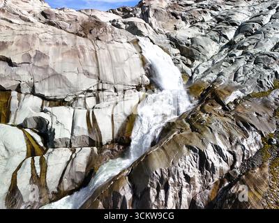 Wasserfall am Rhonegletscher – Blick aus der Vogelperspektive auf das Gletschermelzwasser in den Schweizer Alpen Stockfoto