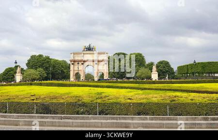 Der Arc de Triomphe du Carrousel in Paris, Frankreich, steht mit seiner kunstvollen neoklassizistischen Architektur. Der Bogen ist mit Statuen geschmückt, Stockfoto