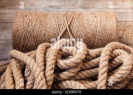 Ein dünnes manila-Seil und ein Haufen dickes Seil liegen auf dem Laminat. Stockfoto