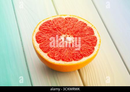 Geschnittene Grapefruit auf blauem Holzhintergrund Stockfoto