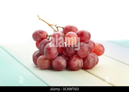 Rote Traube auf Holz Hintergrund auf weiß Stockfoto
