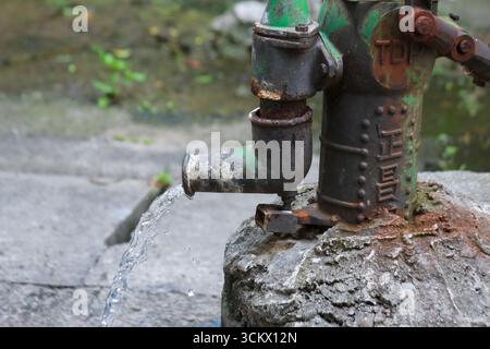 Taoyuan City, Taiwan - 1. Juni 2012: Eine manuelle Wasserpumpe der Marke Cheng Chang, die Anzeichen von Rost und Verschleiß zeigt, gibt aktiv Wasser ab. Xian G Stockfoto