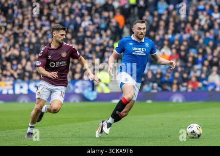 13. September 2025. Glasgow, Großbritannien. Die Rangers spielten Heart of Midlothian (Hearts) in einem Premiership-Spiel im Ibrox Stadium, Glasgow, Großbritannien. Das Ergebnis war die Rangers 0 - 2 Hearts of Midlothian. John Souttar (R5) und Claudio Braga (H10) rennen um den Ball. Stockfoto