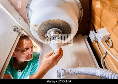 Montage der Abflusseinheit für das Waschbecken, Klempner, der den Ständer aus Kunststoff unter dem Küchenbecken installiert. Stockfoto