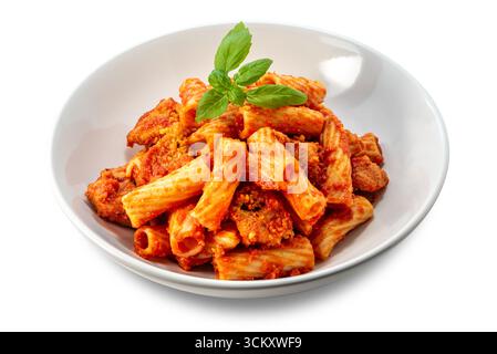 Tortiglioni-Nudeln mit Tomatensauce, Fleischstücken und frischen Basilikumblättern auf einer weißen Platte isoliert auf weiß mit Schnittpfad enthalten Stockfoto