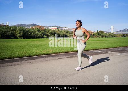 Afrikanische Millennials-Frau, die im Park joggt und Sportbekleidung trägt Stockfoto