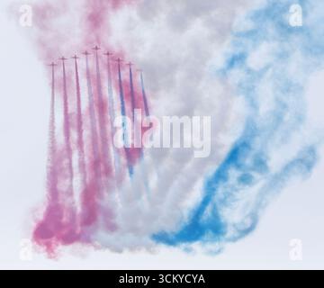 Die Red Arrows, offiziell bekannt als Royal Air Force Aerobatic Team, folgen ihren charakteristischen roten, weißen und blauen Rauchpfaden am Anfang der Th Stockfoto