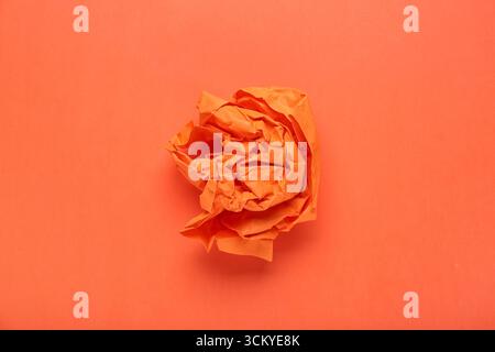 Zerknittertes Papier auf orangem Hintergrund Stockfoto