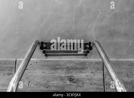 Silbertreppen Und Stilles Wasser – Minimalismus Am Pool. Einfarbige Farbtöne. Stockfoto