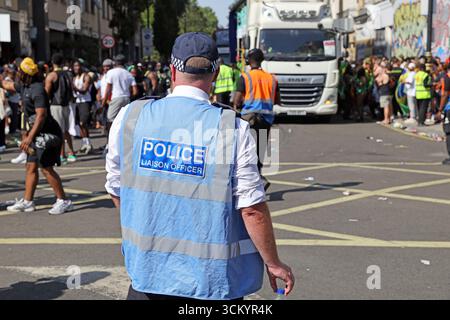 Der Polizeibeamte des Metropolitan Police Service überwacht die Menschenmengen während des Notting Hill Carnivals in London Stockfoto
