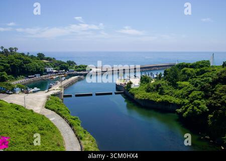 Daepo Port liegt unterhalb des Jungmun Touristenkomplexes, wo eine enge Bucht und niedrige Wellenbrecher zum Meer hin öffnen. Kleine Boote, ein Kai und eine ruhige Becken-App Stockfoto