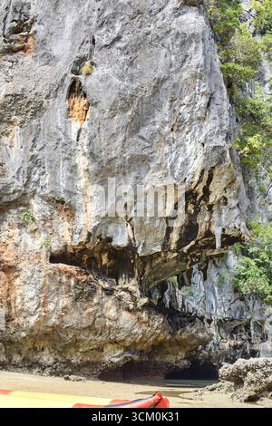 Zerklüftete Küstenklippe mit erodierten Felsformationen und Vegetation in natürlicher Landschaft. Stockfoto