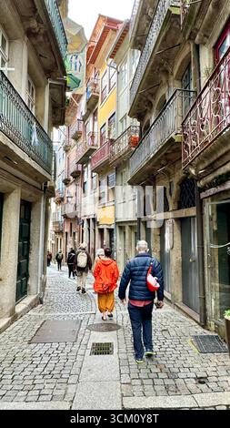 Fußgänger gehen durch die enge Straße Rua da Reboleira im historischen Zentrum von Porto, Portugal Stockfoto