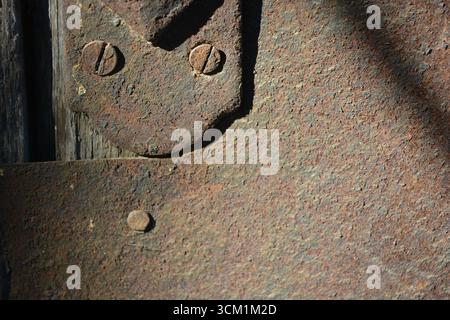 Schönes helles, trockenes Türschloss aus alten Metallteilen mit Rost, Löchern, Unebenheiten, Korrosion. Stockfoto