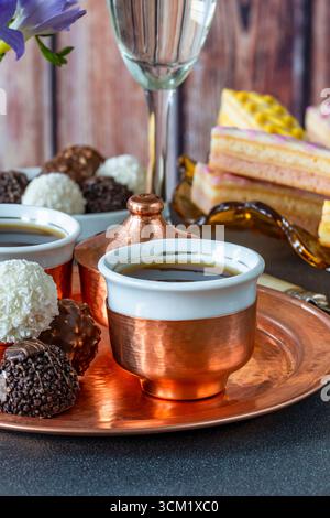 Kaffee und eine Auswahl an Gourmet-Kuchen und Schokoladentrüffeln auf einem Tisch Stockfoto