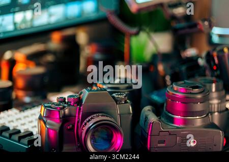 Closeup Retro Kameraobjektiv Modern Creative Workspace mit detailliertem Kameragehäuse im Vintage-Stil mit farbenfrohen Reflexen, umgeben von Objektiven und Video Stockfoto