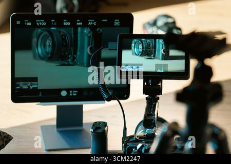 Camera Tethering Setup Video Monitoring Production Workflow zeigt professionelle spiegellose Kamera, die an einen externen Monitor und einen Desktop-Bildschirm angeschlossen ist Stockfoto
