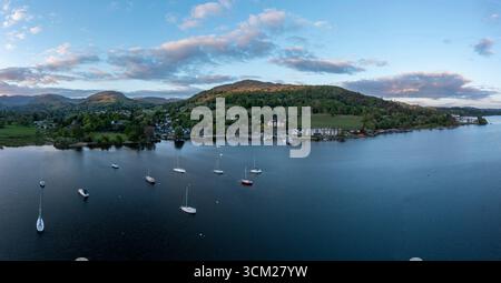 Erhöhter Blick auf den Sonnenuntergang über dem See windermere am waterhead ambleside mit Blick über die Stadt in Richtung der Hügelkette, bekannt als fairfield Hufeisen auf t Stockfoto