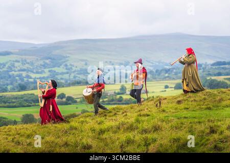 Von links nach rechts, Musiker in traditioneller Kleidung aus dem 15. Jahrhundert, Jackie Phillips spielt eine bray-Harfe, Brad Chick spielt eine mittelalterliche Trommel, Jed Armstrong spielt eine Zitole und Beck Laxton spielt eine Shawm während des Medieval Music in the Dales Festivals auf dem Gelände Bolton Castle in der Nähe von Leyburn, North Yorkshire. Das Festival findet in und um Bolton Castle statt, das 1399 von der adligen Familie Scrope erbaut wurde. Am Wochenende erwacht die Gegend mit Musik und lebendiger Geschichte zum Leben, da sie eine Gemeinschaft mittelalterlicher Musikbegeisterter zusammenbringt. Bilddatum: Sonntag, 14. September 2025. Stockfoto