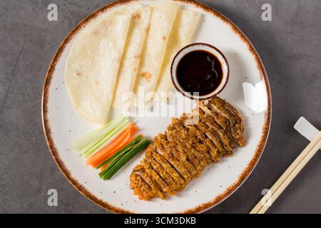 In Scheiben geschnittene knusprige Ente, serviert mit Pfannkuchen, Hoisin-Sauce und Gemüse Stockfoto