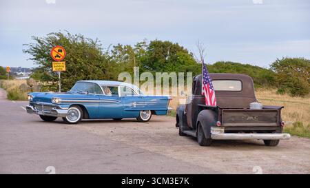 Helsingborg, Schweden; 12. August 2025: Oldsmobile Oldsmobile Oldsmobile und Oldsmobile Hot Rod Pickup, Wenden auf der Küstenstraße Larod bei warmem Sonnenuntergang in der Nähe von t Stockfoto