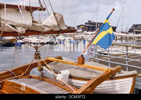 Helsingborg, Schweden; 12. August 2025: Traditionelles hölzernes Yachtheck mit schwedischer Flagge und Schlauchboot im Hafen von Helsingborg. Stockfoto