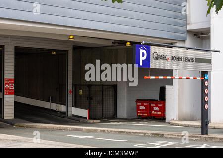 Eine mehrstöckige Parkeinfahrt mit einer Absperrung, Beschilderung und Abfalleimern. Beton- und Metallic-Texturen dominieren die Szene in Liverpool, Großbritannien. Stockfoto