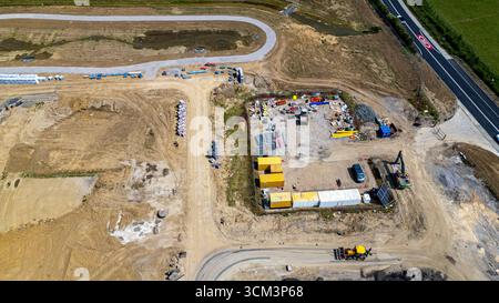 Luftaufnahme einer Baustelle mit verschiedenen Ausrüstungen, Materialien, Versandcontainern und unfertigen Straßen bei Miller Homes in Catterick, Großbritannien. Stockfoto