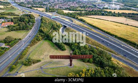 Aus der Vogelperspektive der Engel des Nordens mit einer Autobahn und einer umliegenden Landschaft, mit einer Häusergruppe im Hintergrund in Newca Stockfoto