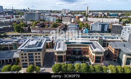 Ein Blick aus der Vogelperspektive auf eine moderne Stadtlandschaft mit verschiedenen Gebäuden, Bäumen und einem mehrstöckigen Parkhaus in Newcastle upon Tyne, Großbritannien. Stockfoto