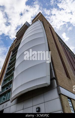 Ein flaches Bild eines modernen Gebäudes mit Ziegelstein- und Glasfassaden mit einer charakteristischen geschwungenen weißen Platte in Newcastle upon Tyne, Großbritannien. Stockfoto