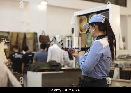 Ein weibliches Mitglied der neu gegründeten syrischen Touristenpolizei steht in blauer Uniform im Innern der Internationalen Messe von Damaskus. Die Touristenpolizei f Stockfoto