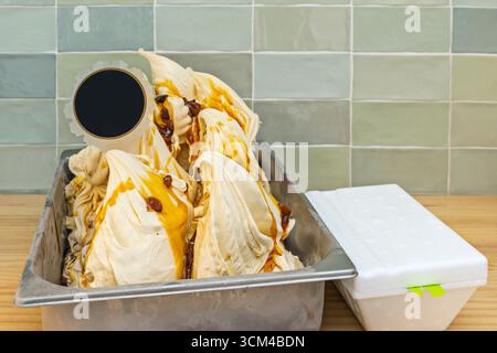 Gesalzenes Karamelleis in einer Wanne, mit Karamelllocken, Brezelstücken und gesalzenen Mandeln, perfekt ausgewogen zwischen süß und salzig Stockfoto